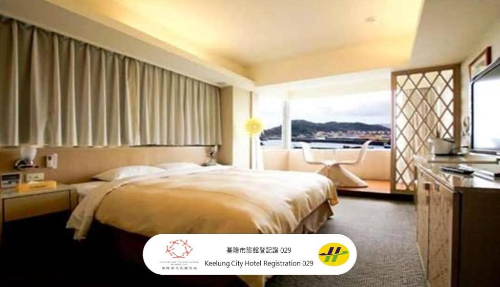 a hotel room with a bed and a large window at Blue Ocean Hotel in Keelung