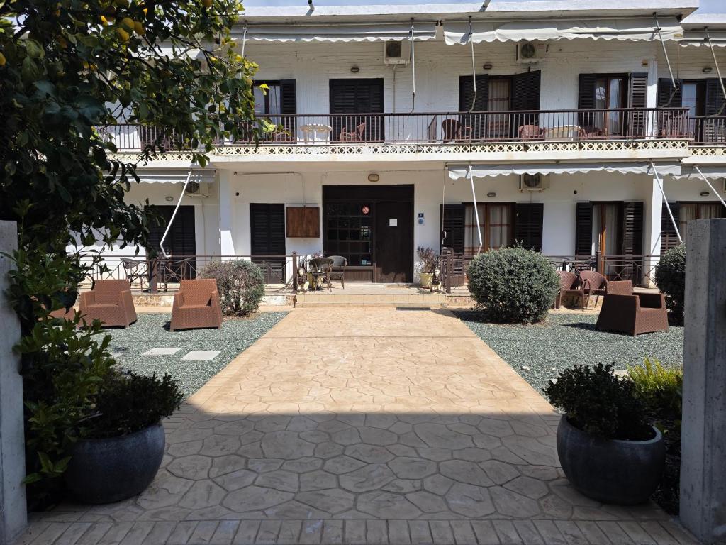 ein Innenhof eines Hotels mit Stühlen und einem Gebäude in der Unterkunft Hotel Apolafsi in Volos