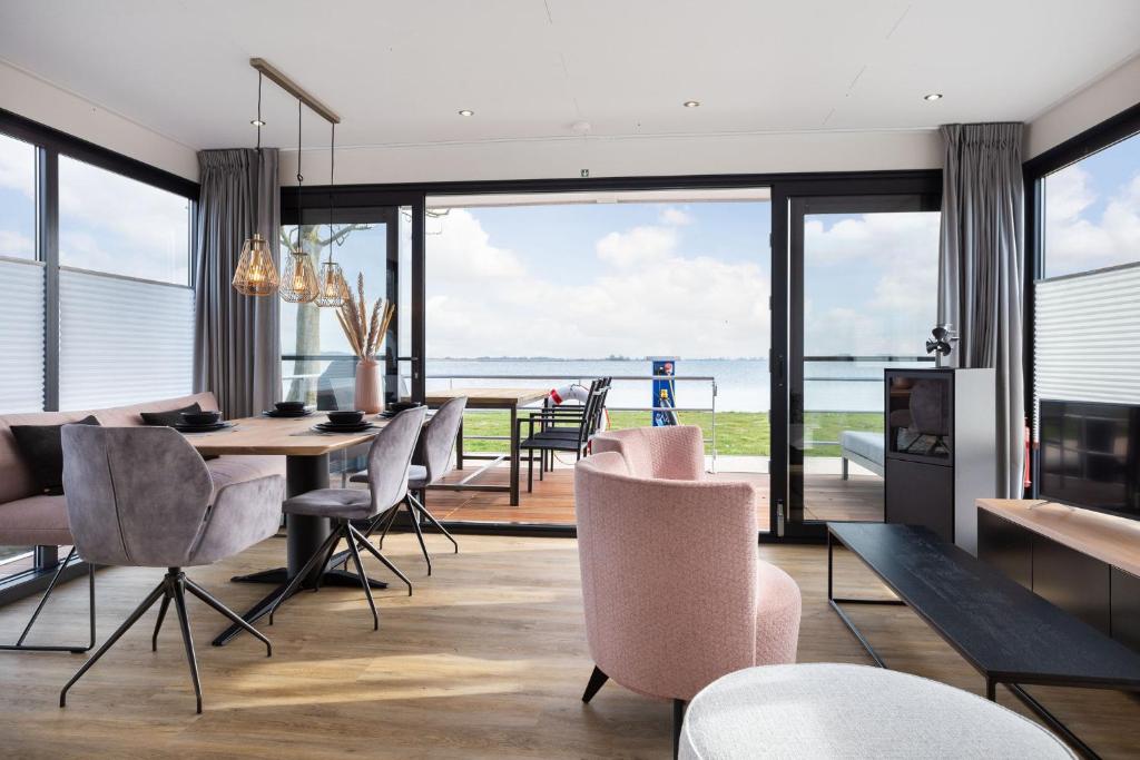 a dining room with a view of the ocean at de Valreep - Paviljoenwei 4 Offinga in Offingawier