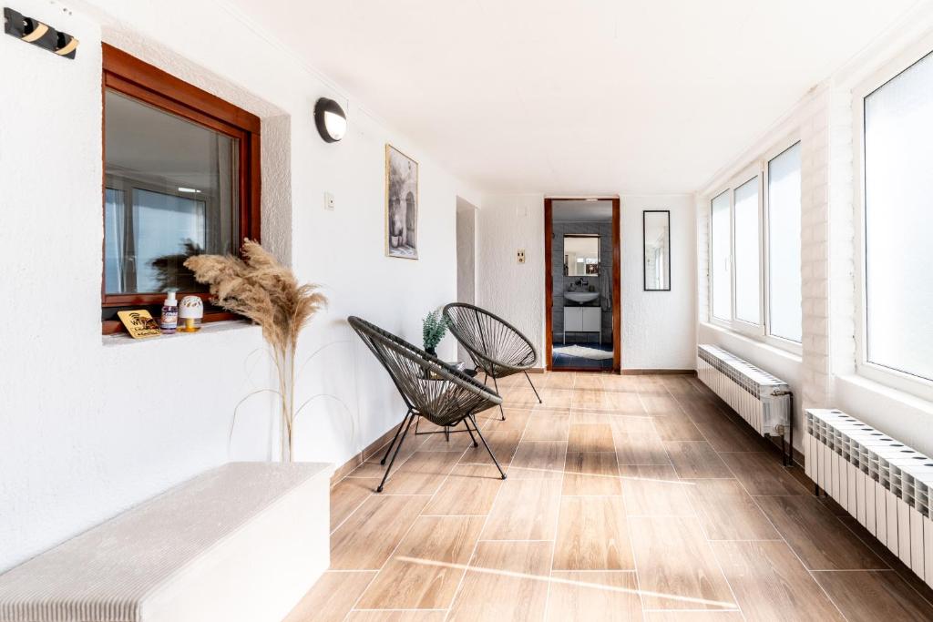 a living room with white walls and wooden floors at Apartman Suman in Vukovar