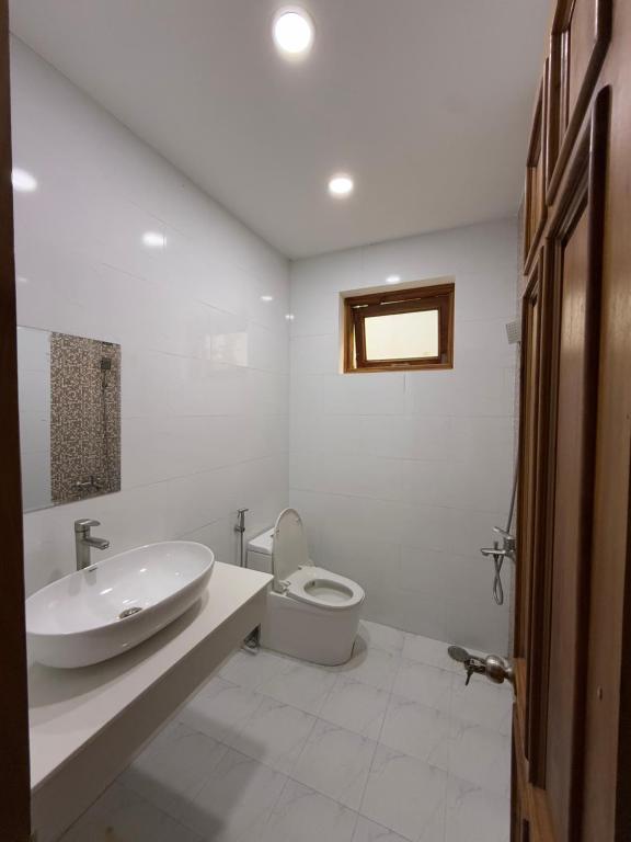 a white bathroom with a sink and a toilet at vuyen villa in Phú Quốc