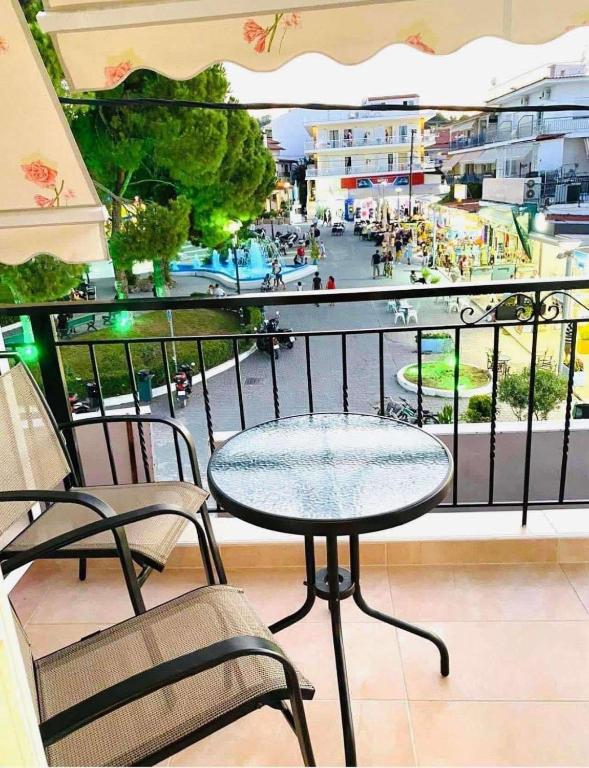 a table and chairs on a balcony with a view of a city at Jasmin Apartments Brown in Hanioti