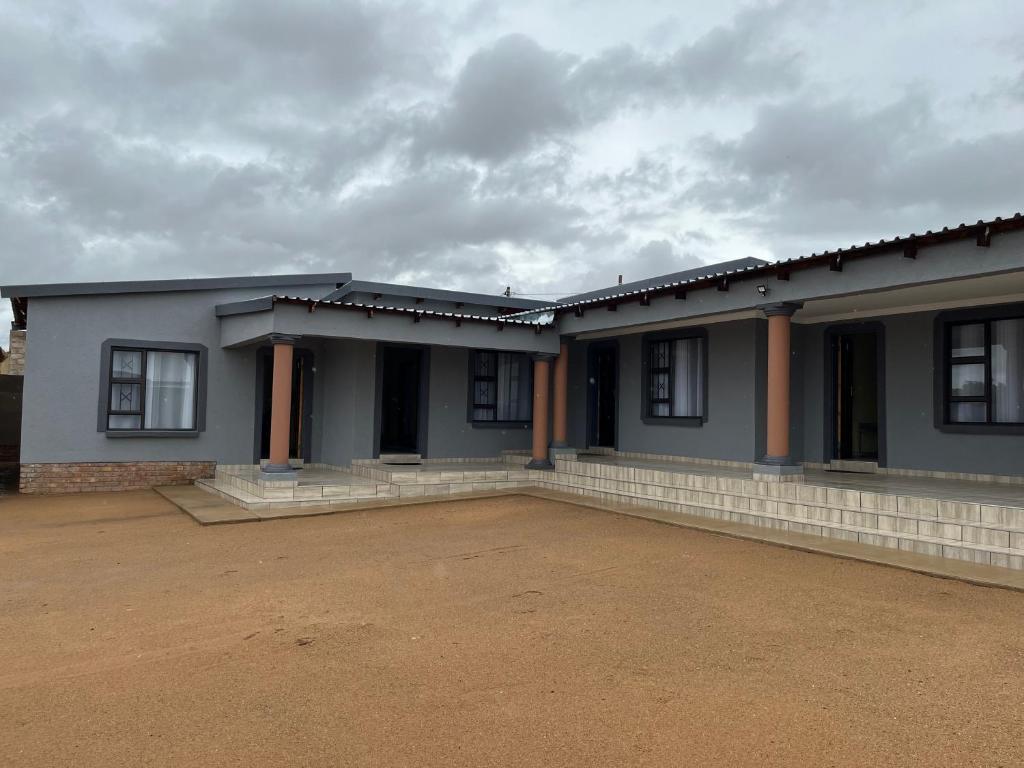 a house with a lot of windows and a cloudy sky at The Arrose Guest House in Kwamhlanga