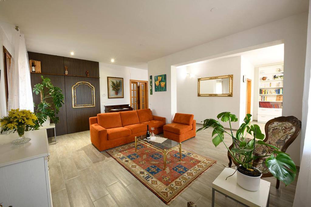 a living room with an orange couch and a table at Il loggiato del chianti in Cavriglia