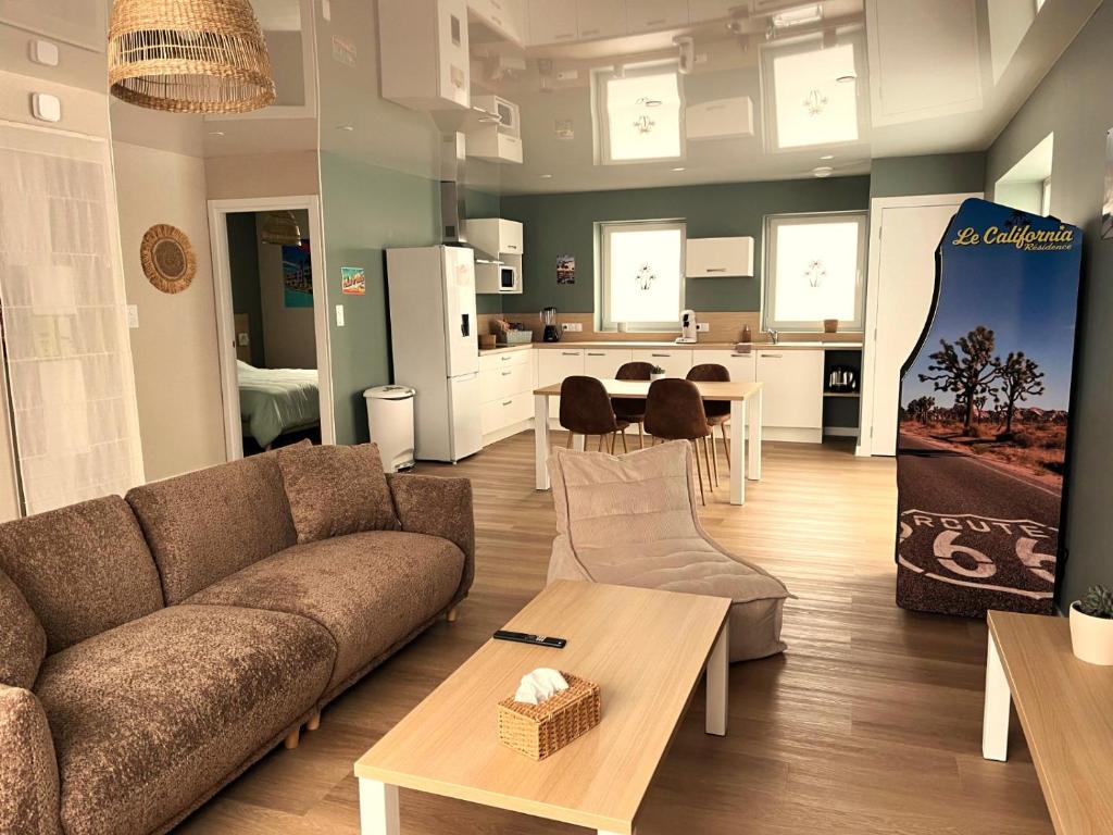 a living room with a couch and a kitchen at Appartement cosy ambiance Palm Spring dans résidence avec piscine 4 pers 2 chambres in Neuf-Mesnil