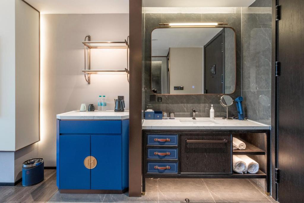 a bathroom with a blue sink and a mirror at Maihao Hotel in Rujiazhuang