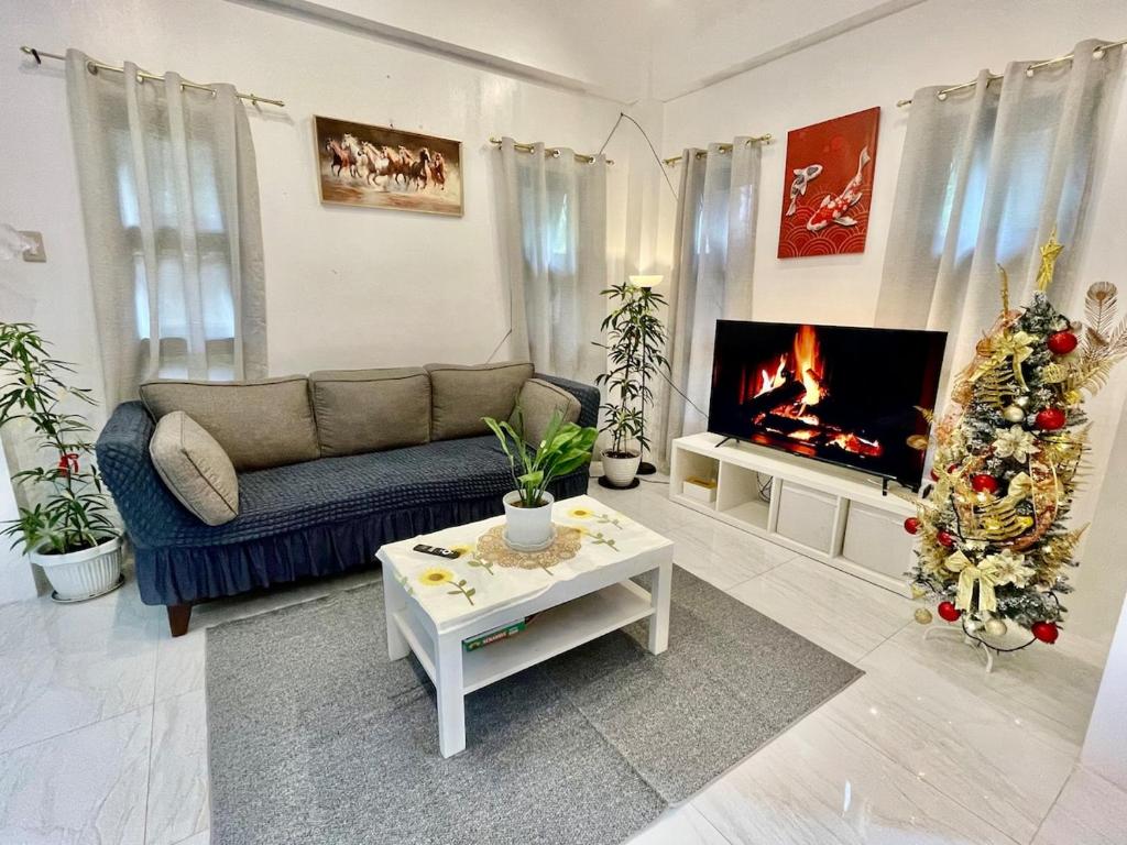 a living room with a couch and a christmas tree at Qagayon Homestay in Sampong