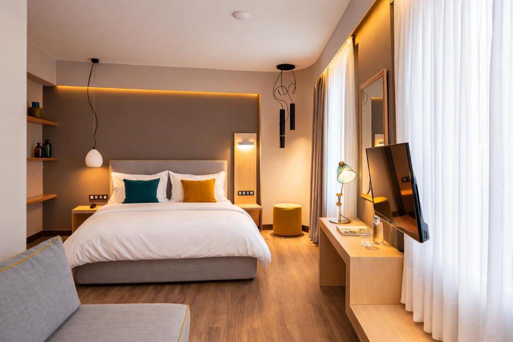 a bedroom with a bed and a flat screen tv at St. Bjur Suites in Athens
