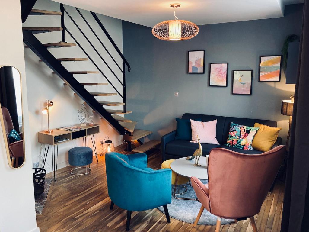 a living room with a couch and a table and stairs at La bulle des Viennes MAISON CLIMATISEE - CHAMPAGNE in Sainte-Savine