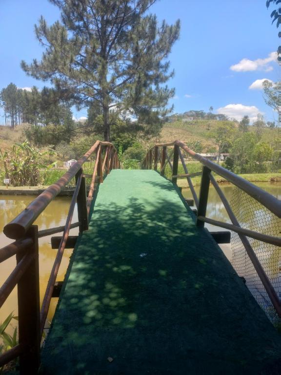a wooden bridge over a river with a green path at Sitio Estoril in Cotia