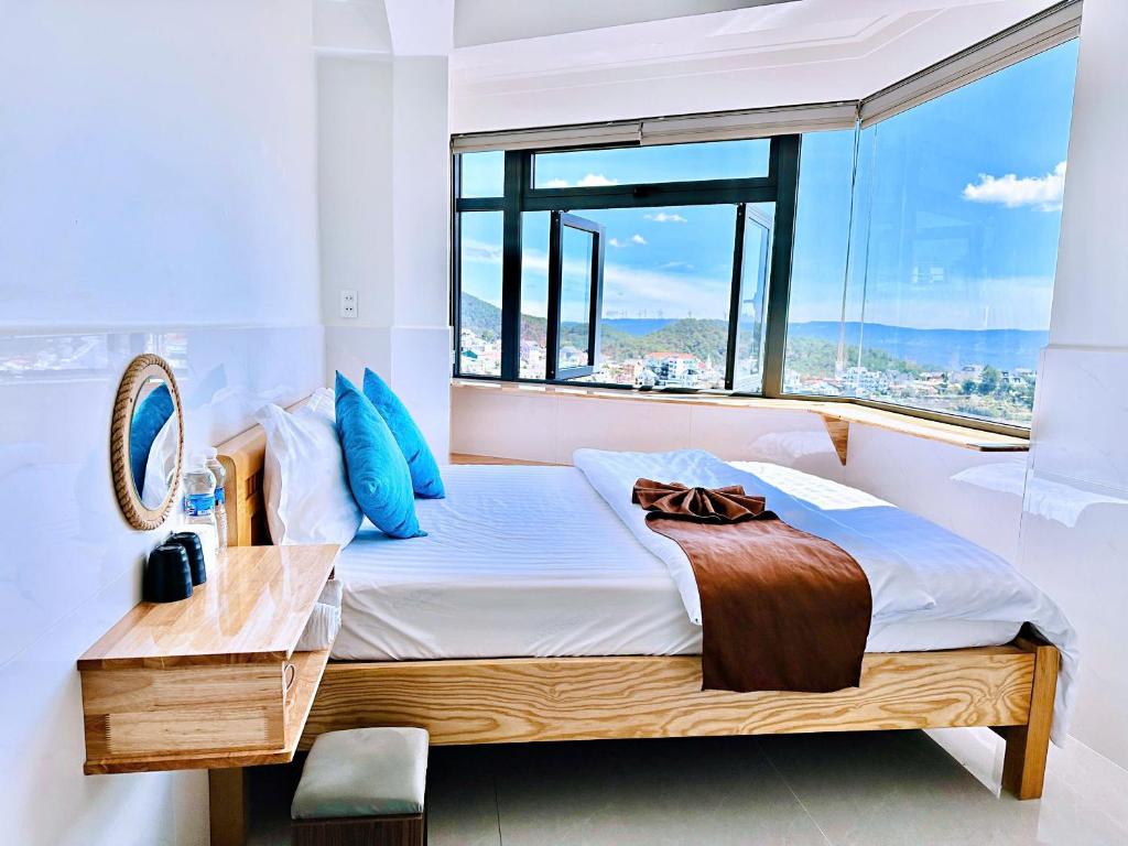 a bedroom with a bed with a large window at Villa Đà Lạt Trung Nghĩa in Ấp Ða Lợi