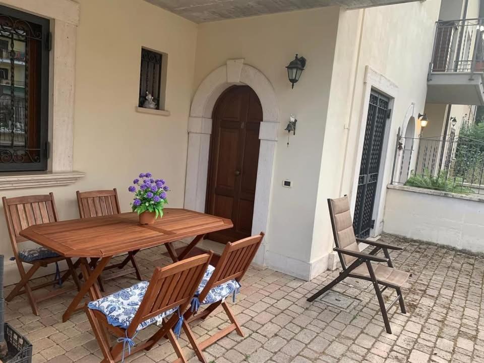 a wooden table and chairs on a patio at Pescasseroli center Case del Parco in Pescasseroli