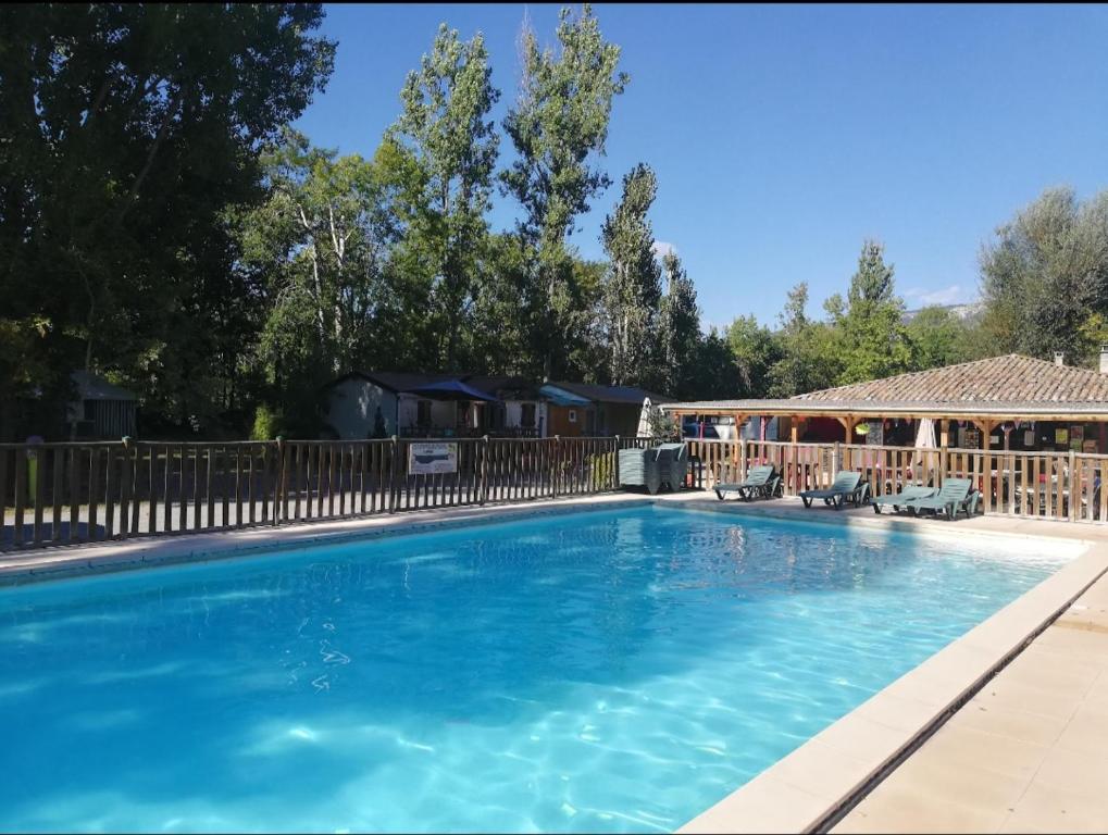 a large swimming pool with a wooden fence at camping de l'or bleu in Barrême