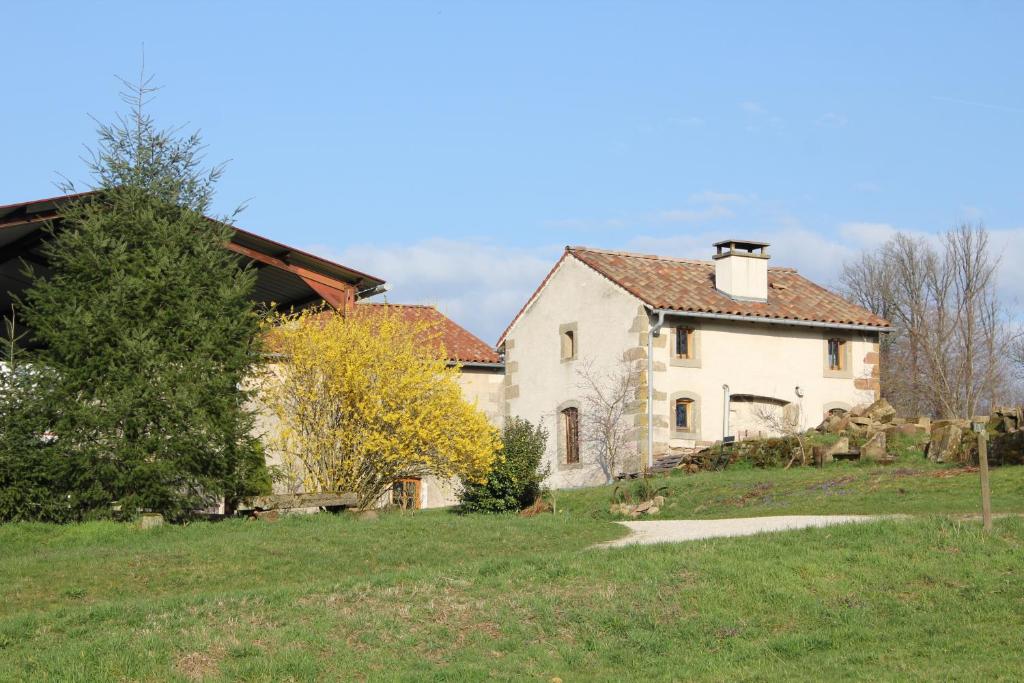 an old white house on a grassy field at La Cabiole in Claudon