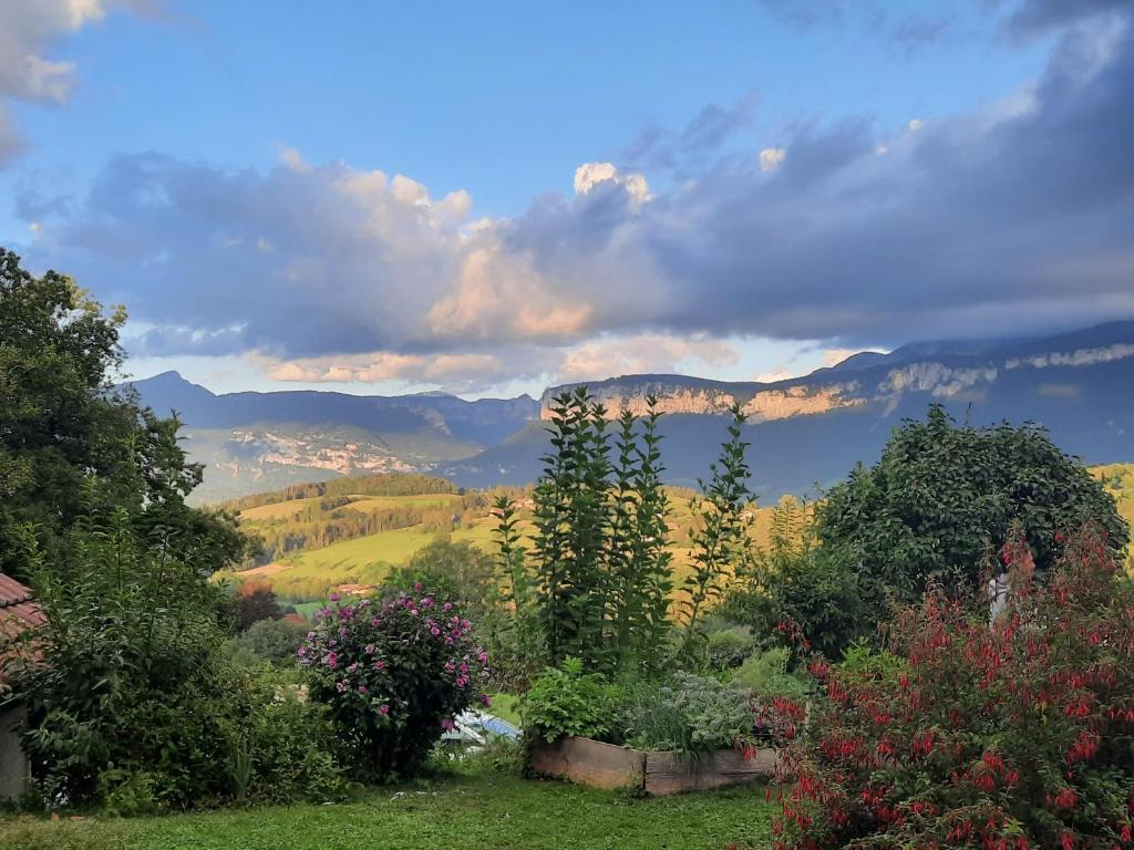 a view of a garden with mountains in the background at Maison au calme en Chartreuse in Miribel-les-Échelles