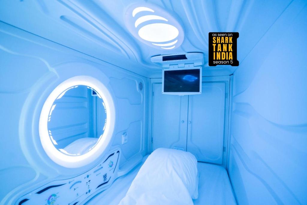 a small room with a round window and a bed at NapTapGo - Japanese Premium POD Hotel - Walk to Noida Electronic City Metro! Wifi, Lounge in Noida