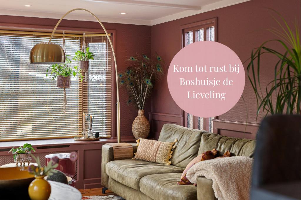 a living room with a couch and a pink wall at Boshuisje met privétuin bij Kruisbergse bossen Achterhoek in Hummelo