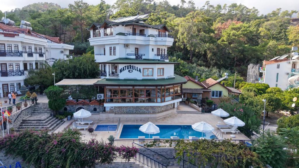 a hotel with a swimming pool in front of a building at NATURELLA APART HOTEL in Kemer