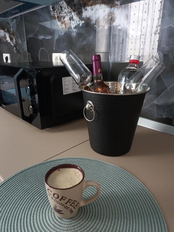 a cup of coffee on a table with a bucket of wine at Apartament Matthias in Mangalia