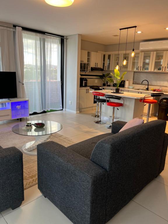 a living room with a couch and a kitchen at 51 Lazarett Loft & Car Rental in Windhoek