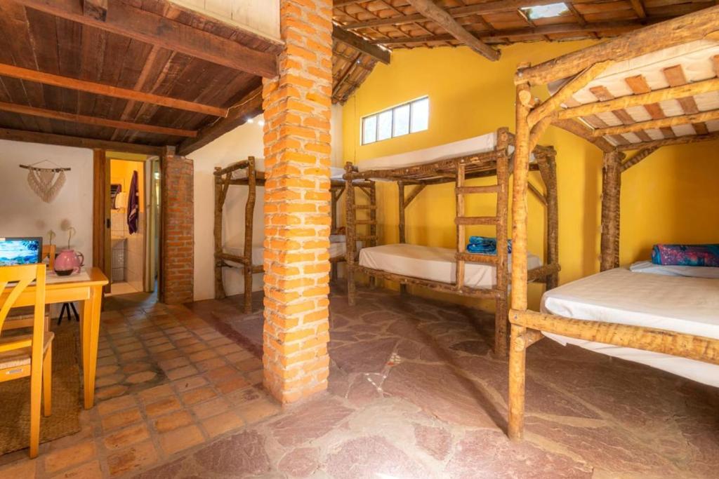 a room with two bunk beds and a desk at Hospedaria Quintal dos Sonhos in Vale do Capao
