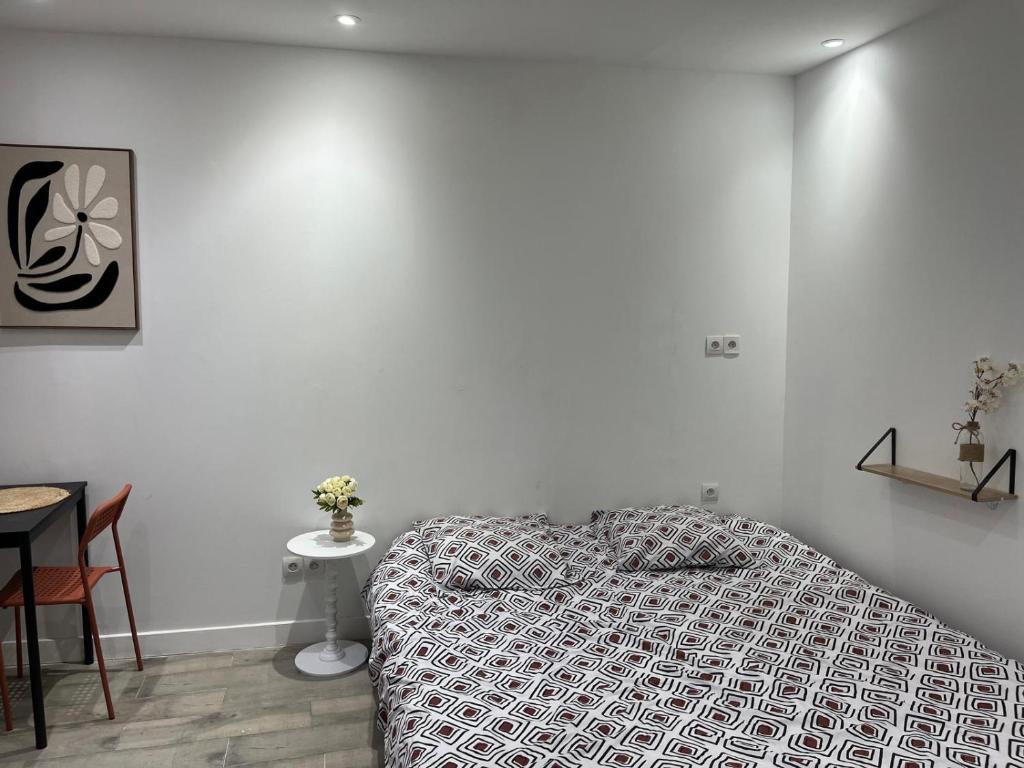 a white bedroom with a bed and a table at Studio proche vieux port in Marseille