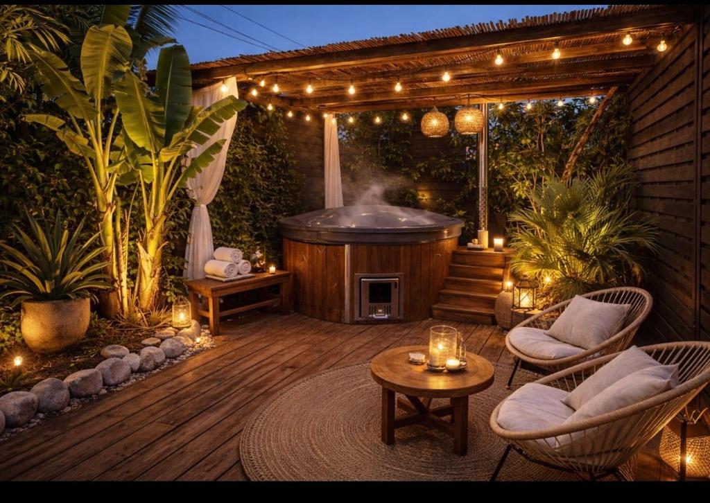 a patio with a hot tub and a table and chairs at Casa Amor in Fretin