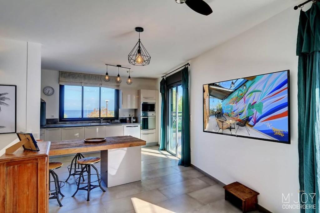 a kitchen with a large painting on the wall at TIGOUYA - House of 135m - 2 bedrooms Jacuzzi in Stella Matutina