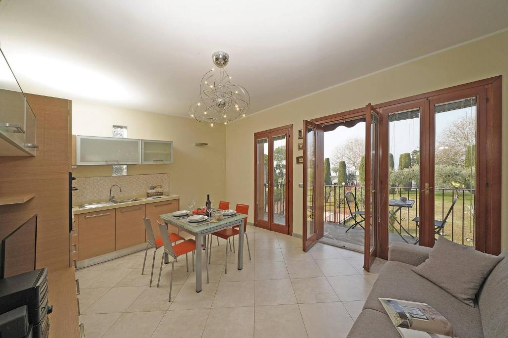 a kitchen and a living room with a table and chairs at Apt Il Barcone - Gardagate in Sirmione