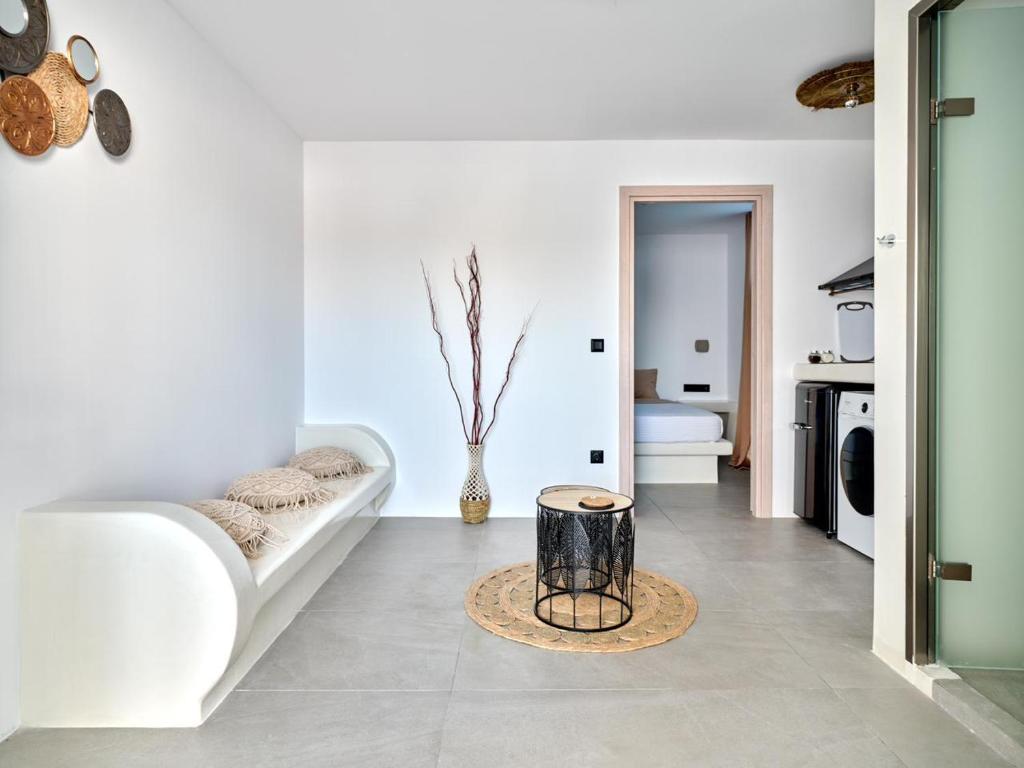 a white living room with a couch and a table at Cozy Hideaway Room with Private Jacuzzi in Krotiri