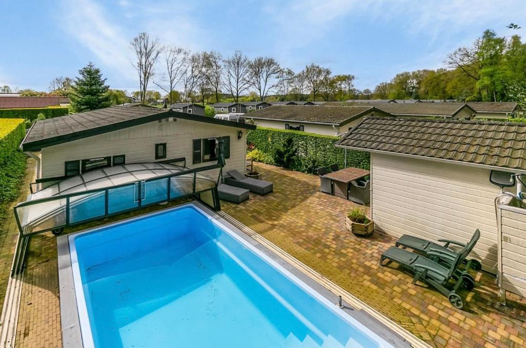 an overhead view of a swimming pool in front of a house at De Bosparel in Doldersum