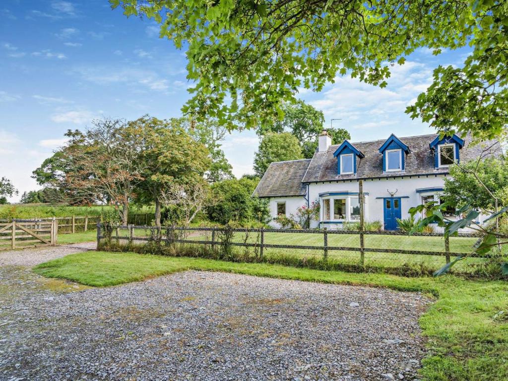an old white house with blue windows and a fence at 5 Bed in Dunkeld oc-90585 in Dunkeld