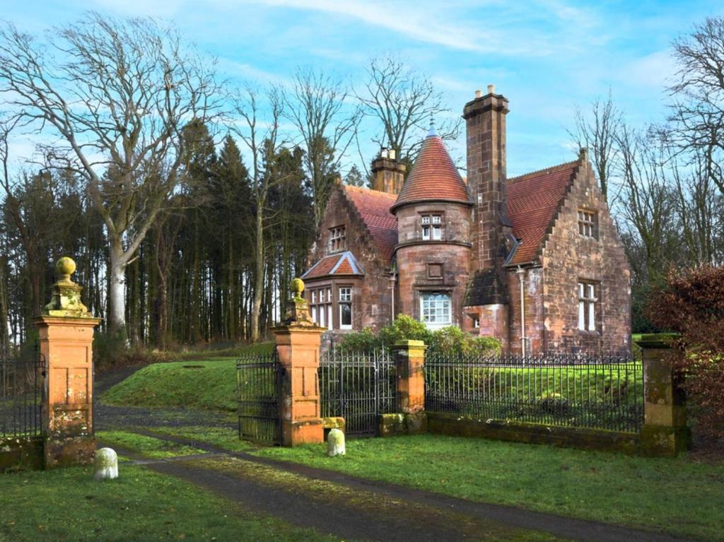 an old house with a gate in front of it at 3 Bed in Lockerbie oc-95861 in Brydekirk