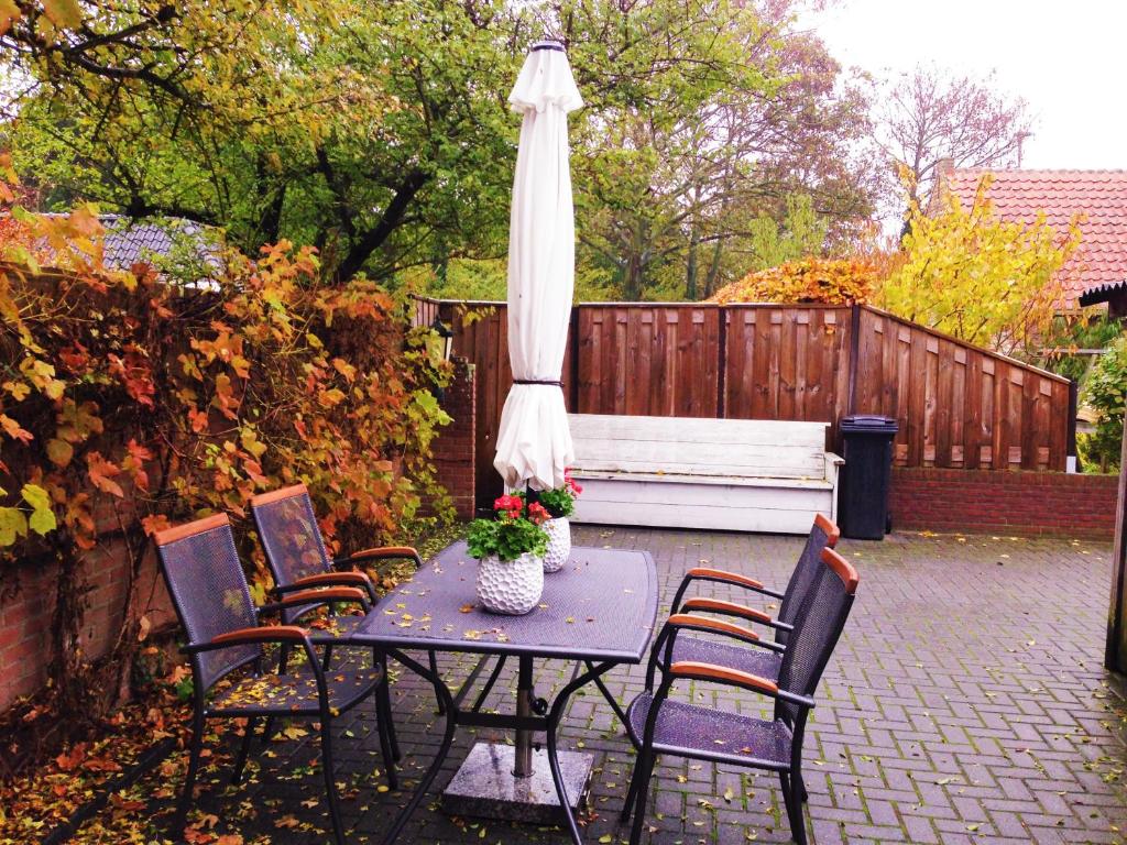 einen Tisch und Stühle mit einem Regenschirm und einer Bank in der Unterkunft Vakantiehuis in het centrum van Domburg in Domburg
