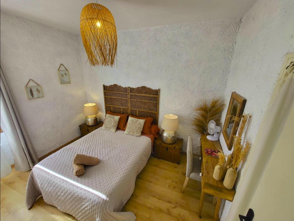 a bedroom with a bed and a table with two lamps at GARDENHILL familly 2 chambres in Argelès-Gazost