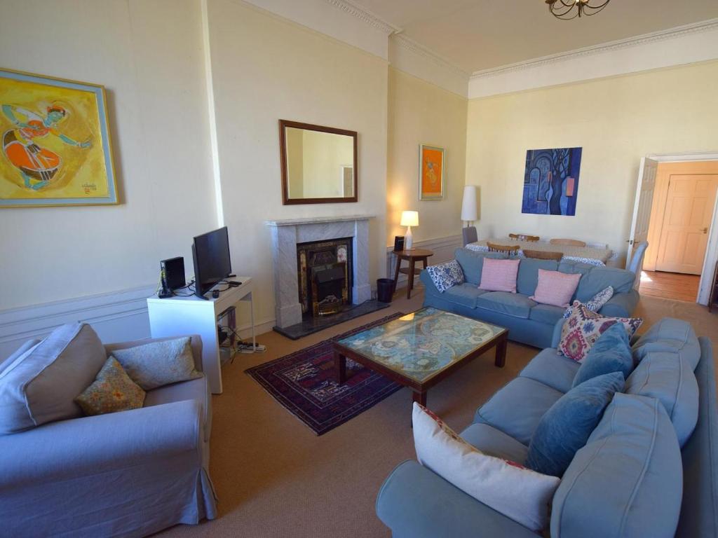 a living room with blue couches and a fireplace at 3 Bed in Edinburgh oc-79008 in Edinburgh