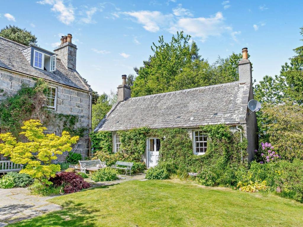 an old stone house with a garden in front of it at 1 Bed in Nethy Bridge oc-28823 in Nethy Bridge