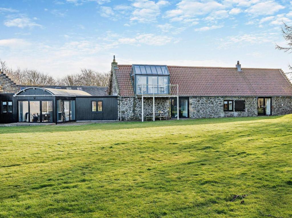 a stone house with a large lawn in front of it at 3 Bed in Cupar oc-54394 in Peat Inn 