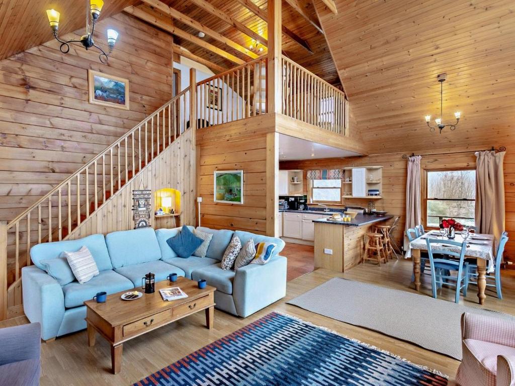 a living room with a blue couch in a log cabin at 3 Bed in Fort William oc-95783 in Torlundy