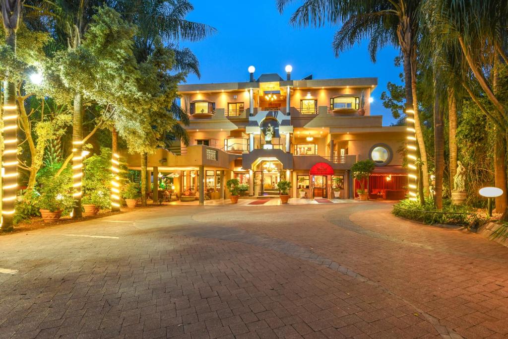 a large building with palm trees in front of it at Villa Simonne in Johannesburg