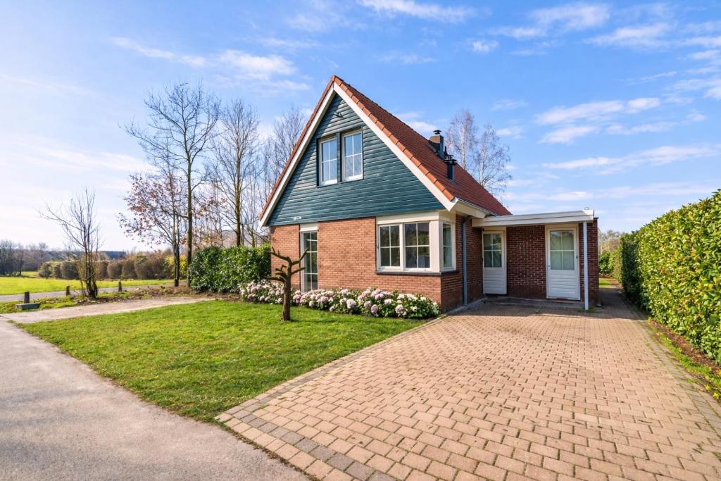 a house with a brick driveway in front of it at Comfort Villa for 8 People in Zeewolde