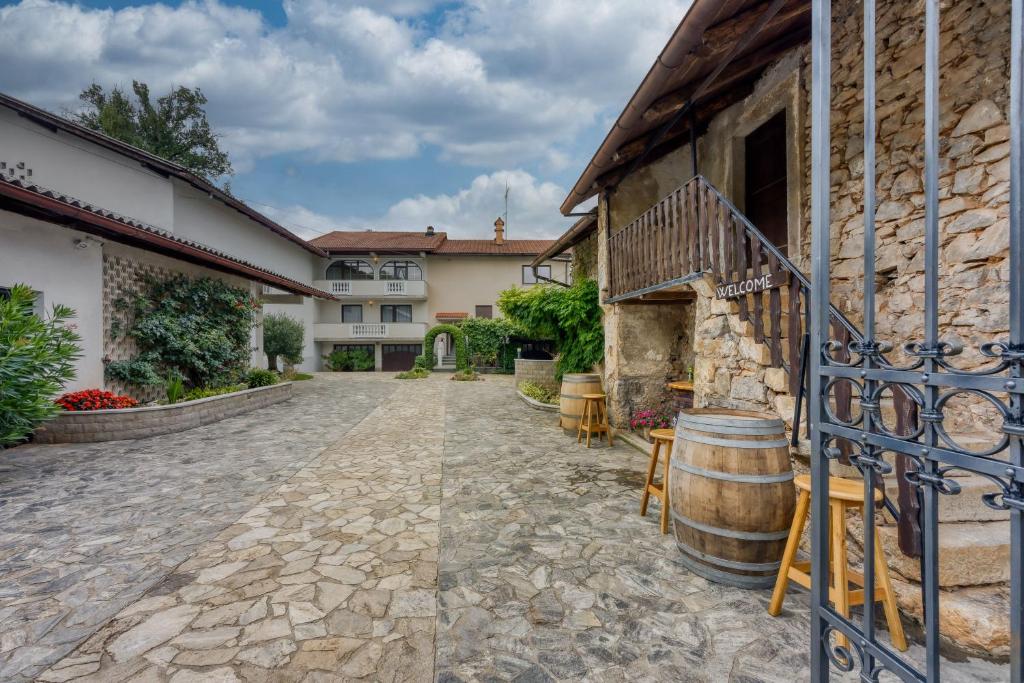 a courtyard of a house with a barrel at Apartma pri Cesarjevih in Sežana