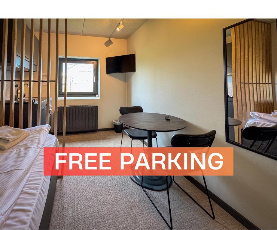 a room with a table and chairs and a bed at Jönköping Hotel Apartments in Jönköping