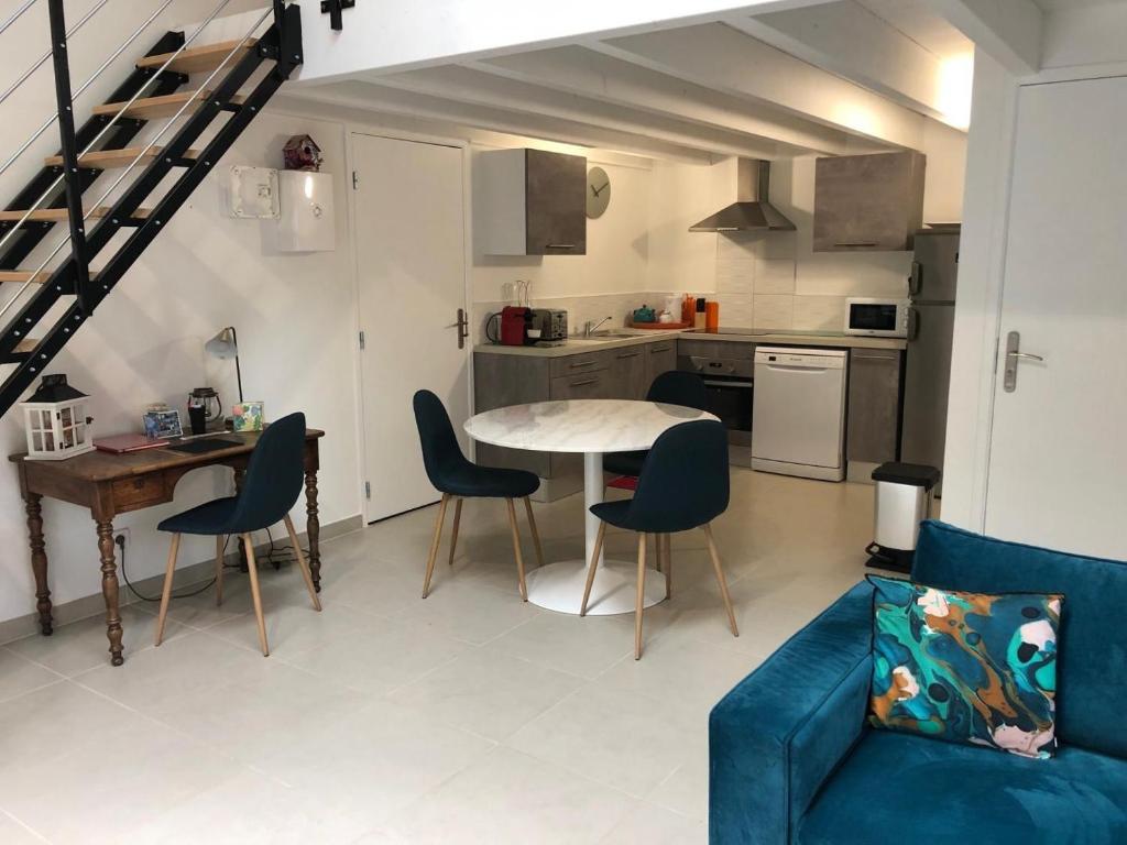 a living room with a table and chairs and a kitchen at Le loft 2 in Vouneuil-sous-Biard