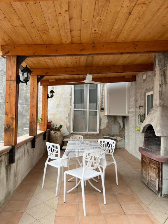 a patio with a table and chairs and a fireplace at La casa del tulipano in Bernalda