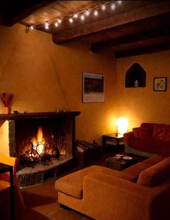 a living room with a couch and a fireplace at Casa Odette Calcata in Calcata