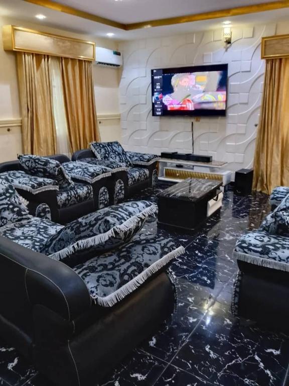 a living room with couches and a flat screen tv at Aduniniyi 7 Shines in Igando