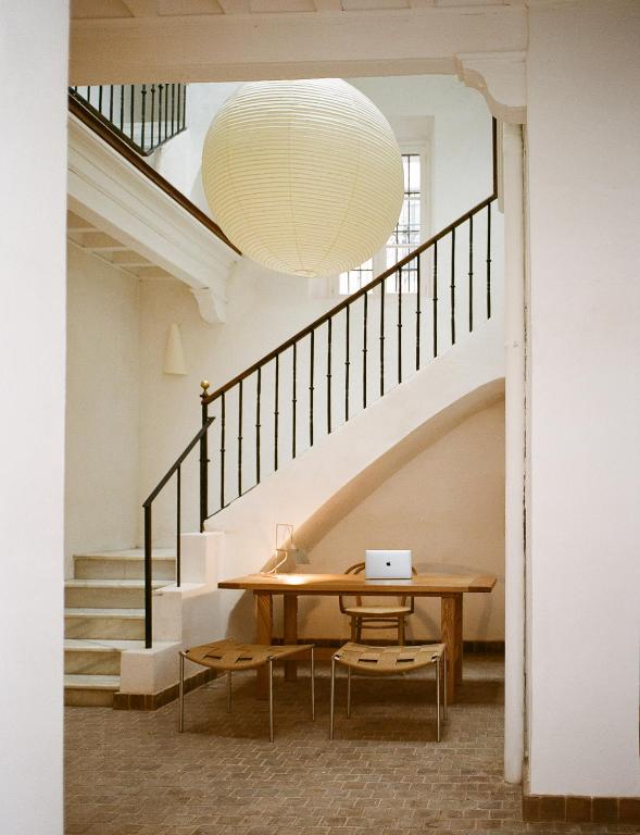 a dining room with a table and a large light fixture at Casa Teva Rooms Sevilla in Seville