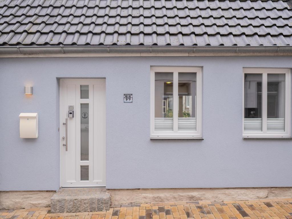 a blue house with a white door and windows at Hafensternchen in Husum