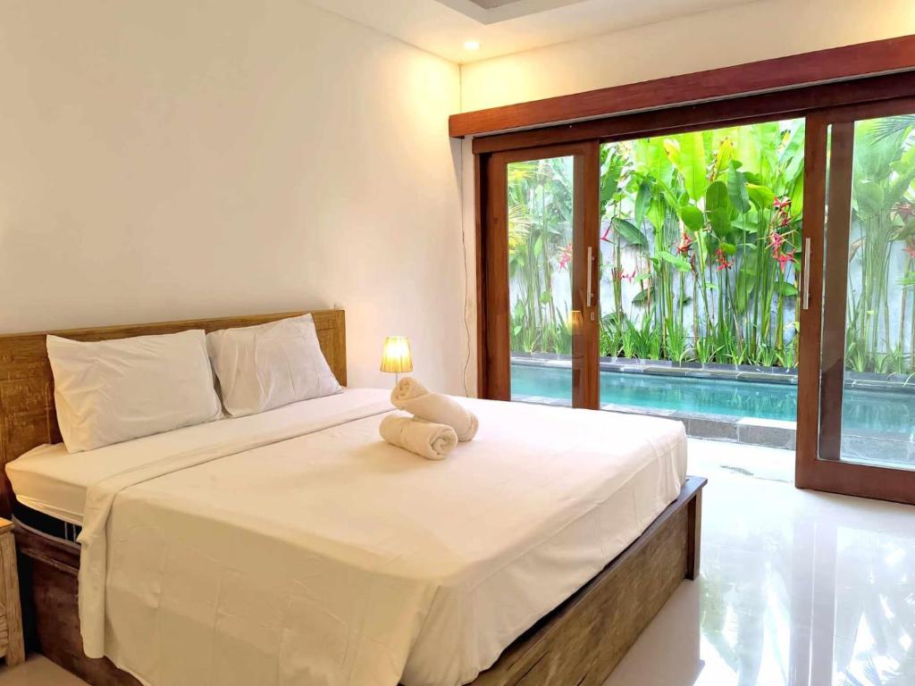 a bedroom with a bed with a teddy bear on it at Nimis Villa in Canggu